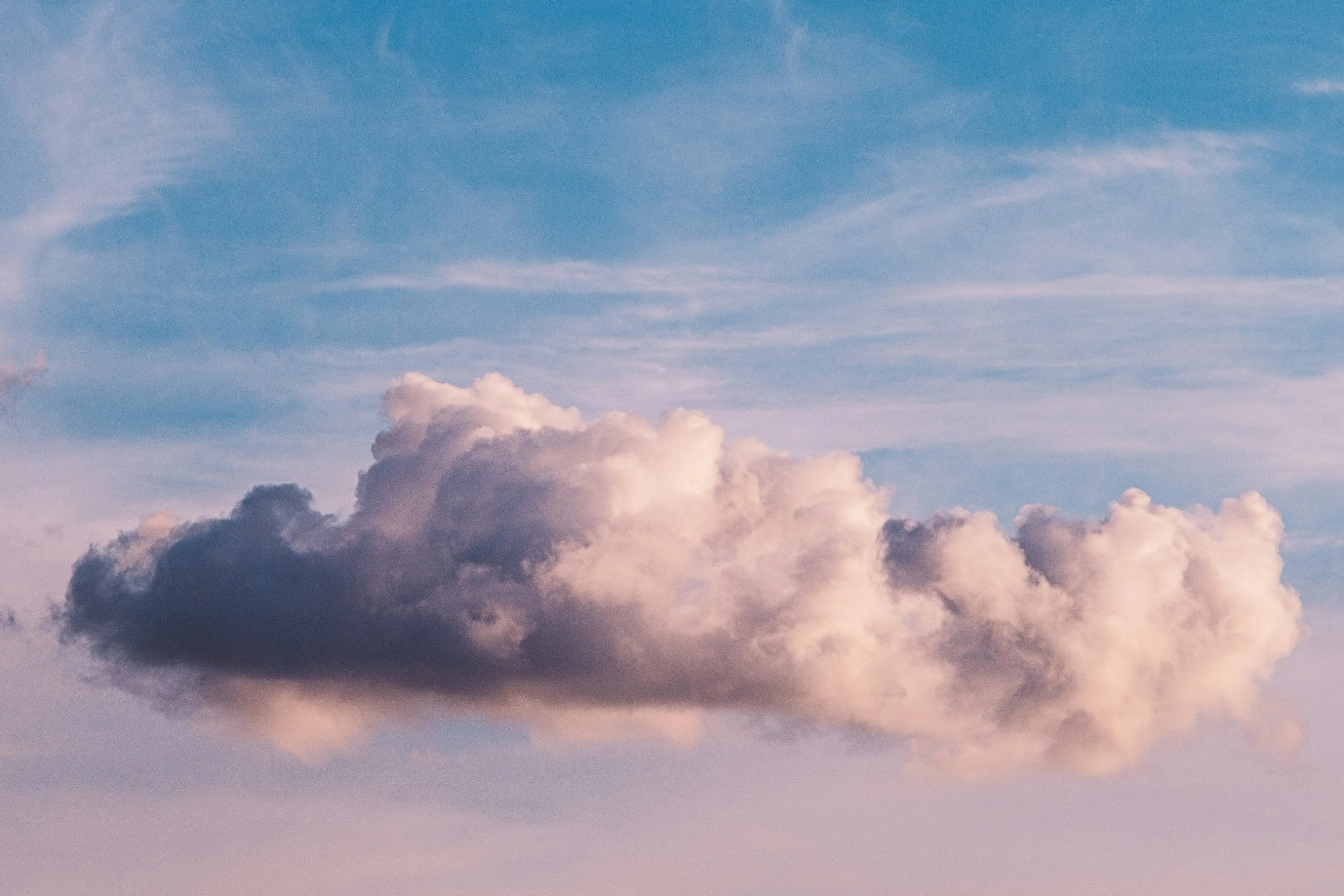 Ett lätt moln mot en ljusblå himmel i kvällsljus